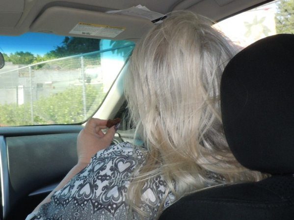 Woman with grey blond hair in a car