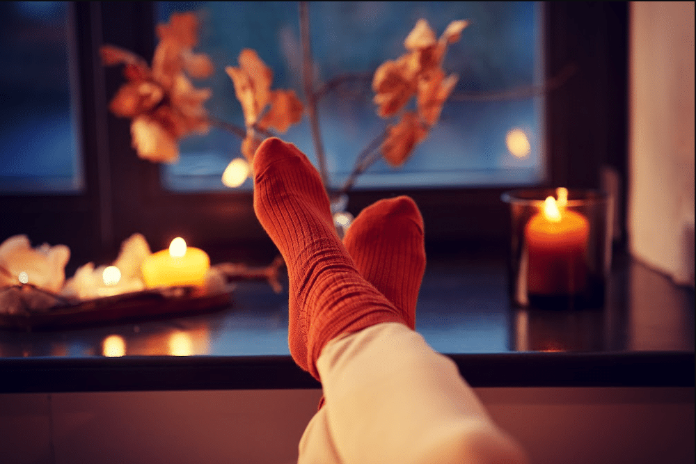 feet up candles and a rain autumn day outside a window