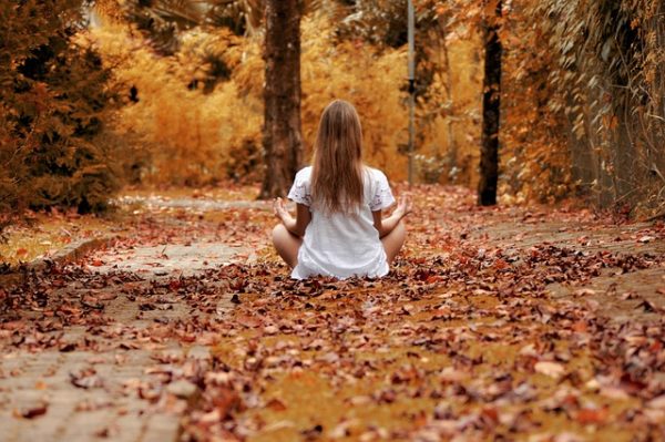 girl sitting in fall leaves