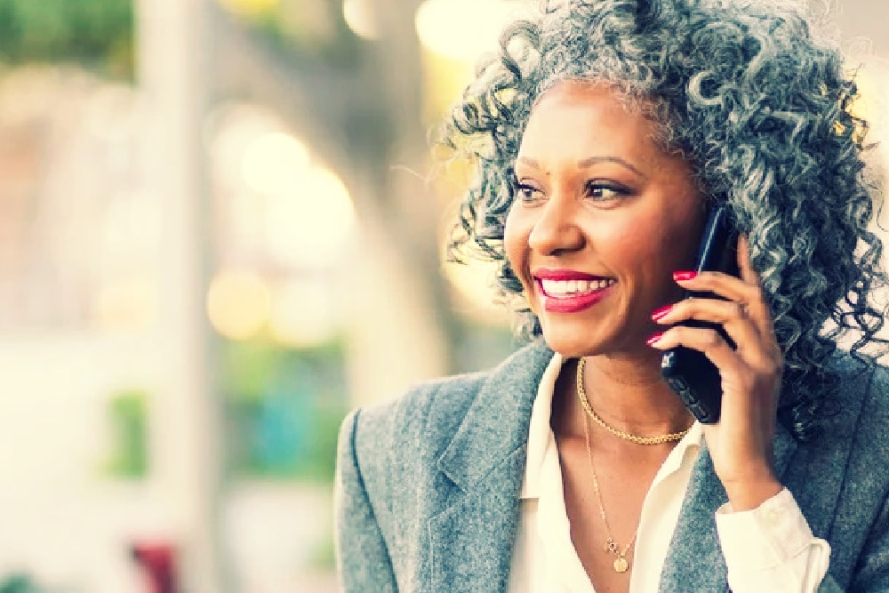 woman over 50 talking on a cell phone smiling