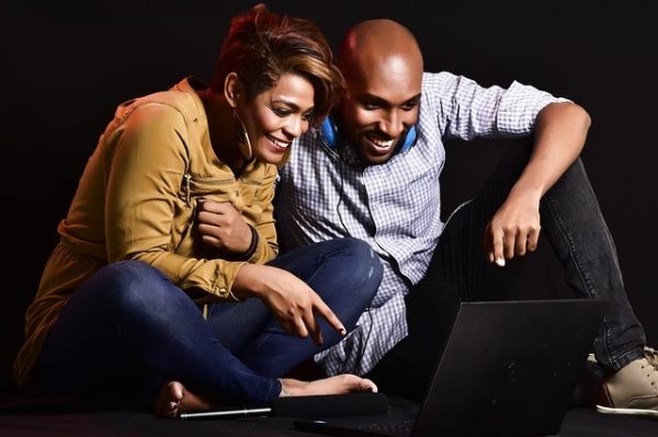 couple watch tv on their laptop