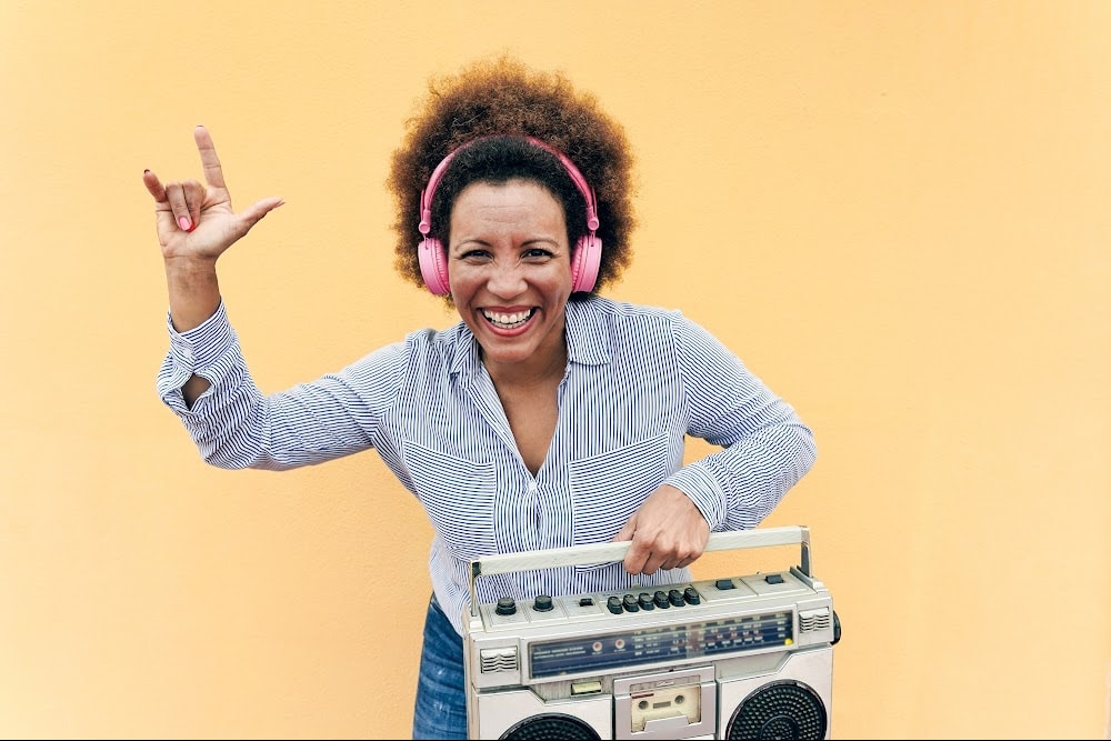 generation x woman with a boombox and headphones smiling