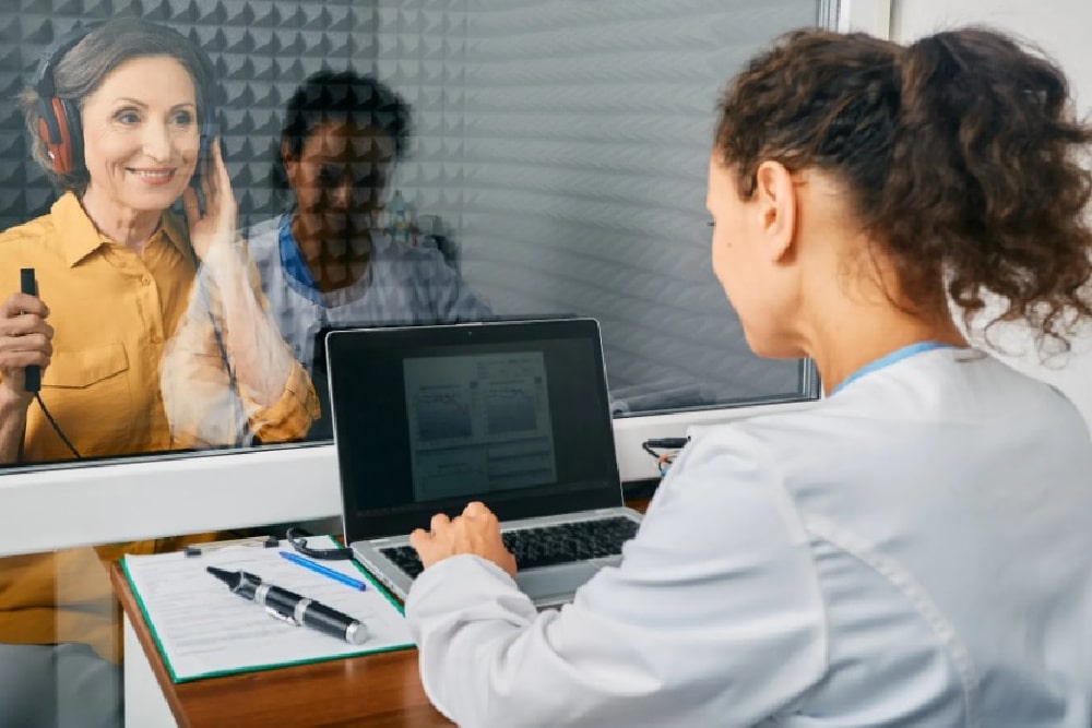 woman over 50 getting a hearing check with an audiologist