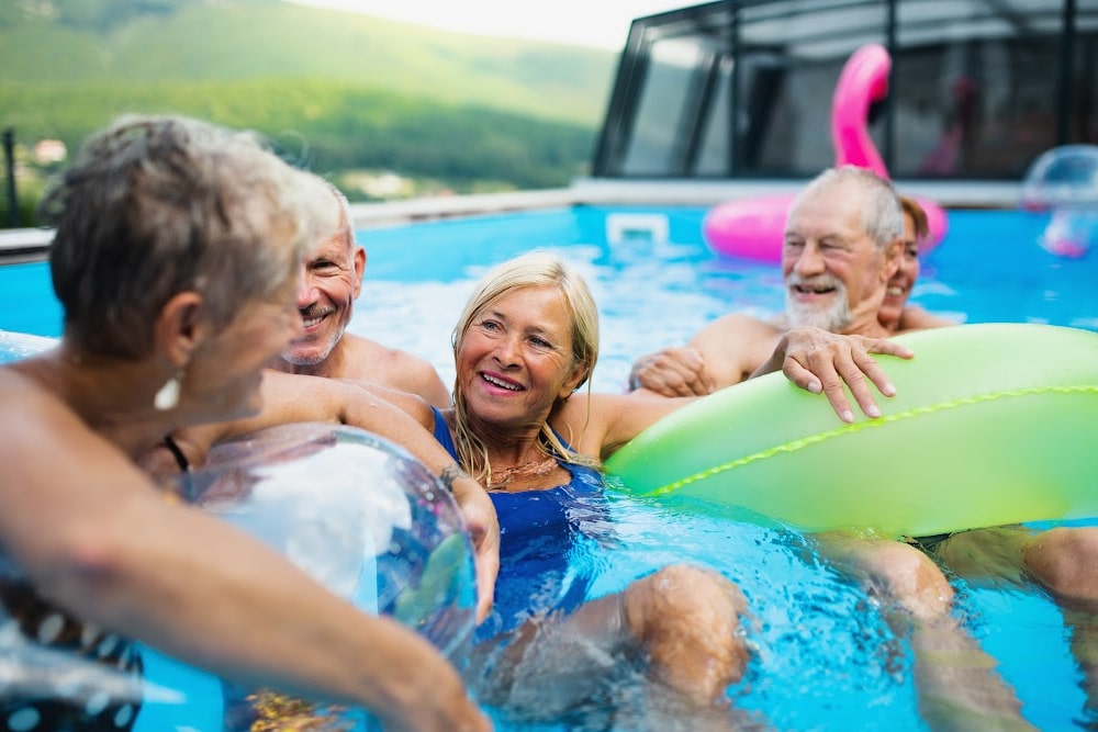 men and women over 50 laughing and enjoying pool ownership