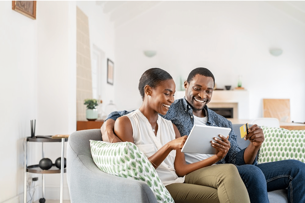 empty nest couple sitting on a couch with a tablet planning for retirement by creating a budget