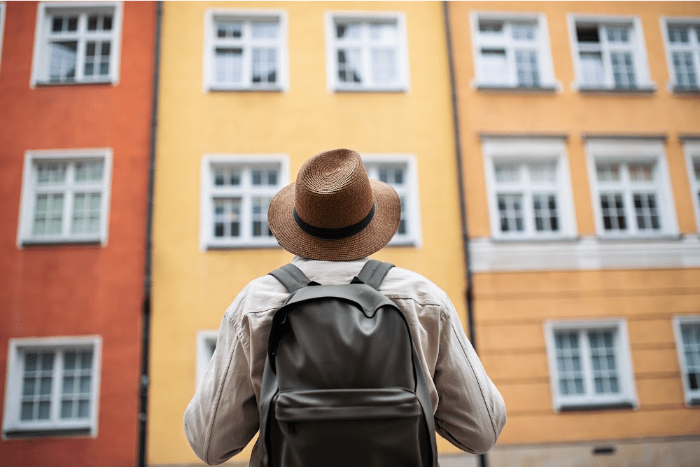 downsizing to an apartment carrying only a backpack looking up at the windows in the building
