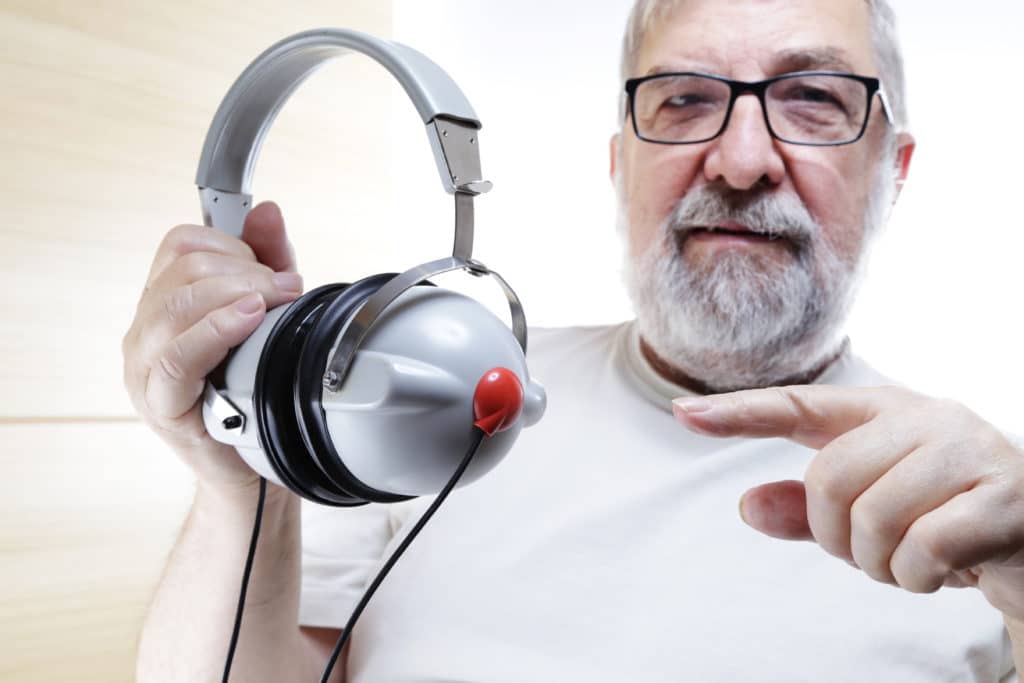 man over 50 holding headphones
