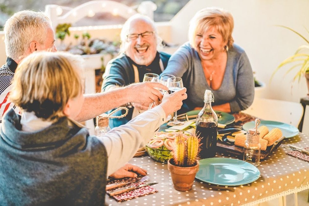 empty nest couples over 40 laughing and dining al fresco in the summer