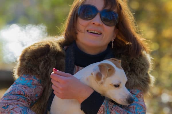 woman over 50 holding a dog outside