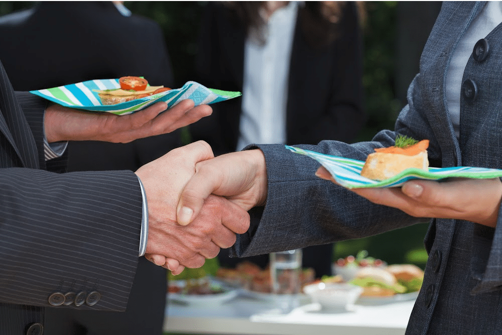 handshake over a catered buffet at business events