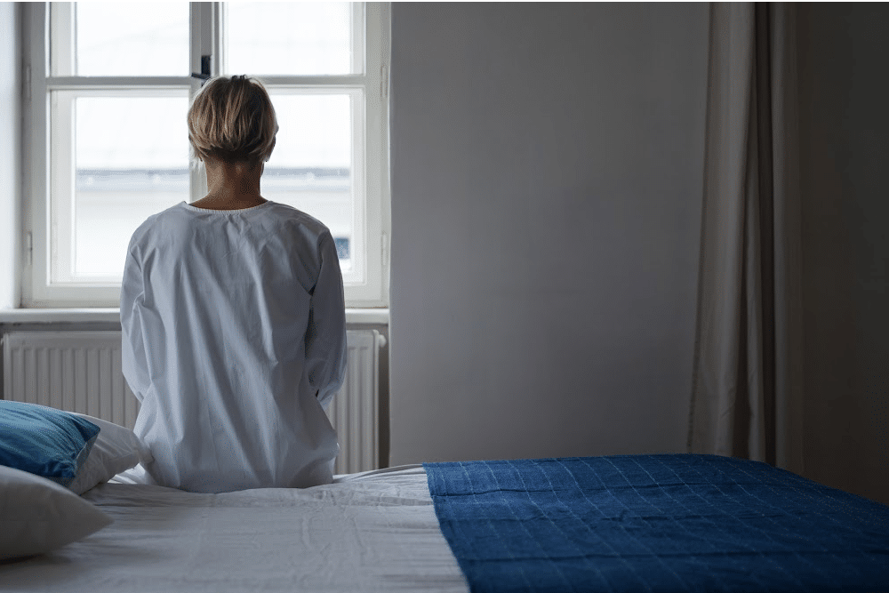 person in a mental hospital looking out a window