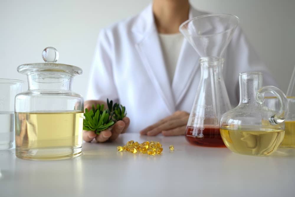 woman pharmacist wearing a white coat with cbn cbg cbd oils and capsules