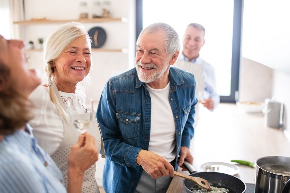 older couples celebrating an empty nest thanksgiving preparing food with friends.