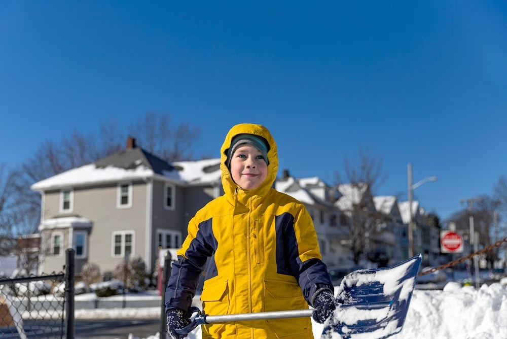 a neighbor kid shoveling snow