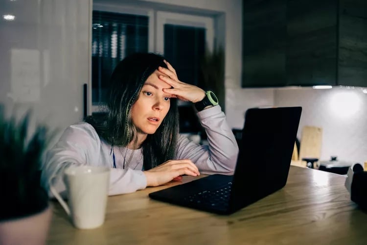 generation x blogger trying to figure out if she should delete a blog post or not looking at her laptop